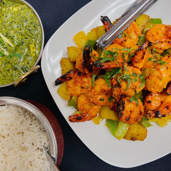 Tandoori shrimp with bell peppers, a bowl of palak paneer, and basmati rice from India Express.
