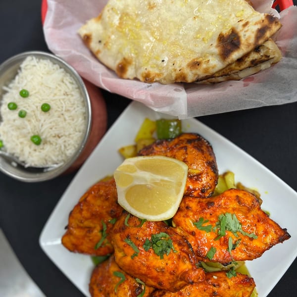 Indian Express Denver's chicken tikka with lemon, rice, and naan bread.