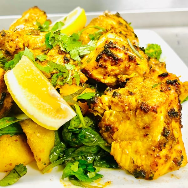 Indian Express Denver's chicken tikka, garnished with fresh cilantro and lemon wedges.