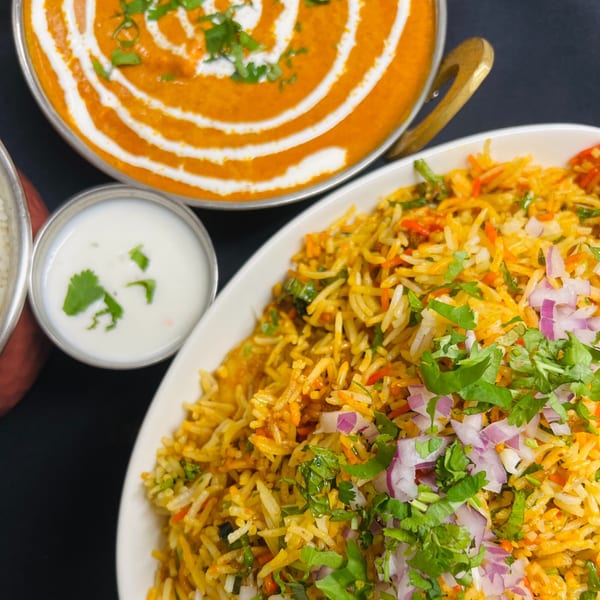 Indian Express Denver's butter chicken, biryani rice with cilantro and red onions, and raita.