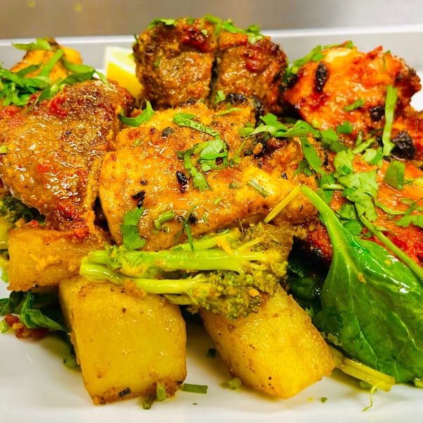 Close-up of Indian Express Denver's chicken tikka masala with potatoes, broccoli, and spinach.
